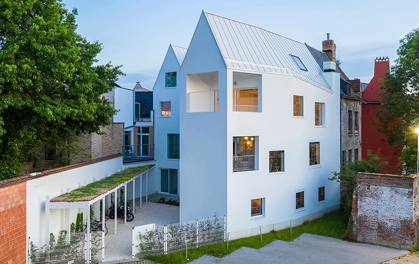 dmvA设计的白色山墙房屋，与比利时历史悠久的城市建筑融为一体