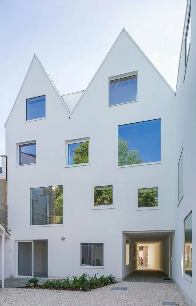 dmvA设计的白色山墙房屋，与比利时历史悠久的城市建筑融为一体